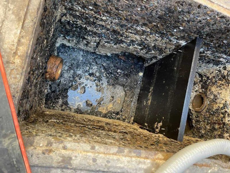 Grease trap repair being performed in a commercial kitchen in Los Angeles County