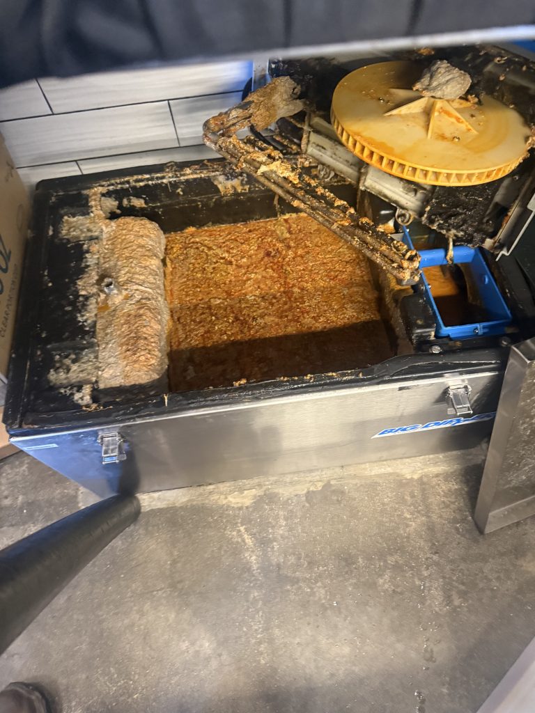 Full grease trap requiring professional grease trap cleaning