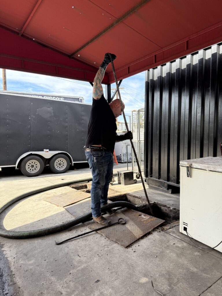 Technician performing grease interceptor repair service at a Los Angeles restaurant